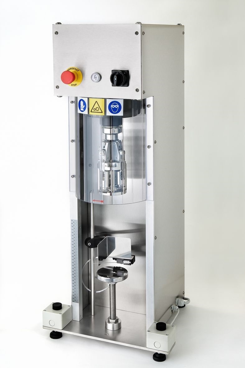 ROPP cap tightening machine applying aluminium caps to bottles